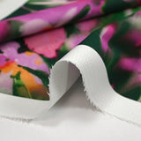 Satin de coton élasthanne fleurs dans le flou fond vert foncé