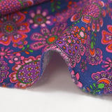 Cotton corduroy printed with psychedelic flowers indigo background