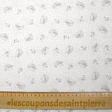 Piqué de algodón con estampado de erizos y lunares color topo sobre fondo blanco.