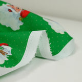 Coton imprimé père Noël à pois fond vert
