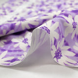 Popeline de coton imprimée vibration de marguerite fond violet