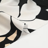 Satin polyester imprimé fragment beige et fleur écrue fond noir