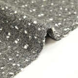 Lainage polyester bouclette et confettis blanc fond gris