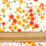 Popeline de coton imprimée fleurs étoilées orange et jaune fond blanc