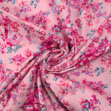 Popeline de coton imprimée bouquet de fleurs fuchsia fond rose dragée