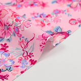 Popeline de coton imprimée bouquet de fleurs fuchsia fond rose dragée