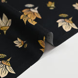 Popeline de coton imprimée fleur jaune pastel et miel fond noir