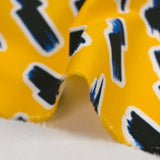 Popelín de algodón ORGÁNICO estampado con fondo amarillo rayo
