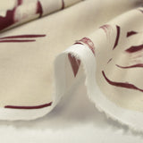 Voile de coton imprimé traces de feuilles fond bordeaux