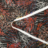 Mousseline imprimée lurex feu d'artifice brique et ocre fond noir