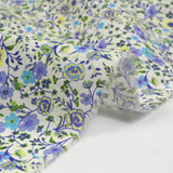 Flores moradas de Giorgia de algodón y fondo azul ECRU por metro