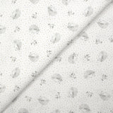 Piqué de algodón con estampado de erizos y lunares color topo sobre fondo blanco.