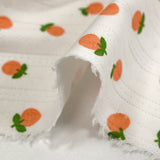 Jersey pointelle coton imprimé orange fond blanc cassé