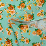 Popeline de coton imprimée bouquet orange fond vert d'eau