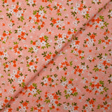 Popeline de coton imprimée composition florale fond rose pêche