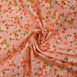 Popeline de coton imprimée composition florale fond rose pêche