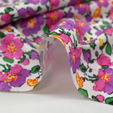 Popeline de coton imprimée brume de fleurs violet et rose fond blanc