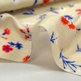 Popeline de coton imprimée envol de fleurs bleu, blanc, rouge fond grège