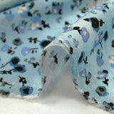 Voile de viscose imprimé fleurs dansantes fond bleu brumeux