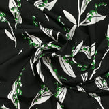 Punto de viscosa satinada estampado con una ramita de lirio de los valles, fondo negro
