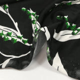 Punto de viscosa satinada estampado con una ramita de lirio de los valles, fondo negro