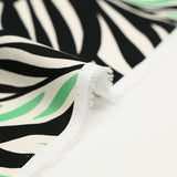 Satin de coton imprimé jungle tribal vert et blanc fond noir