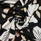 Satin polyester imprimé fragment beige et fleur écrue fond noir